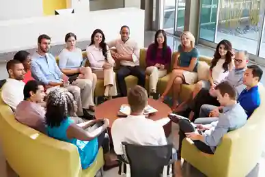 A group of people sitting around in chairs.